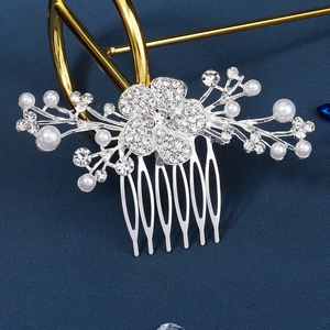 Macro shot of bridal silver hair comb with crystal flowers and pearls on blue texture