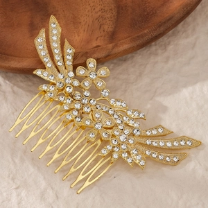 Detail shot of a golden bridal hair comb with rhinestone flowers and feather wings