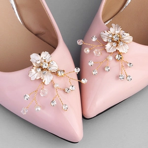 Detail of floral shoe clips with pearls and rhinestones on pink high heels