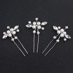 Détail de trois épingles à cheveux de mariée argentées avec perles et strass brillants