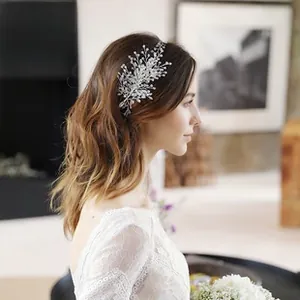 Close-up of bridal headband with silver alloy leaves, pearls and crystals on hairstyle