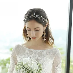 Detailed close-up of golden leaf bridal hair vine with matching crystal pendant earrings set