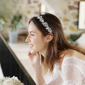Macro detail of silver bridal headband with crystal flowers and white pearls on hair