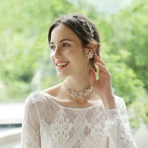 Close-up of bridal jewelry set with pearl flower necklace and sparkling rhinestone headpiece