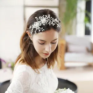 Detailed view of silver bridal hair band with pearls and rhinestones on hair