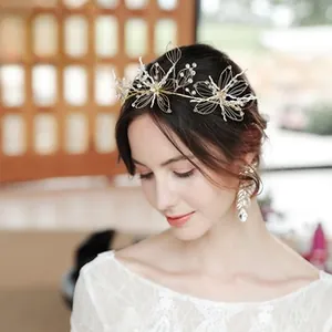 Detail of bridal gold floral headband with white pearls and drop crystal earrings