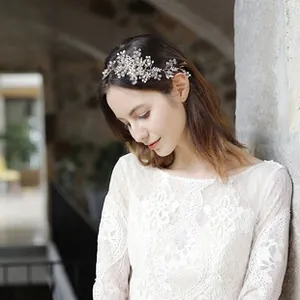 Detailed macro shot of handmade silver bridal headband with pearls and crystal rhinestones