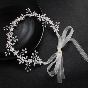 Détail de bandeau de mariée avec perles, cristaux et ruban en organza blanc