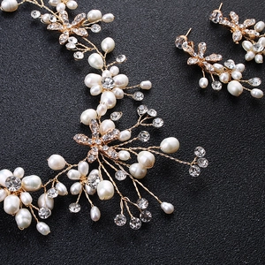 Dettaglio parure sposa con perle fatte a mano e strass su fili di metallo dorato
