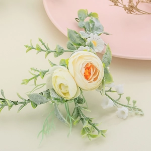 Detailed view of floral bridal hair comb with cream ranunculus and white daisies