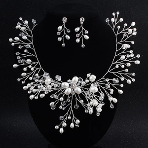 Set di gioielli da sposa con collana di perle e orecchini su un espositore a busto nero