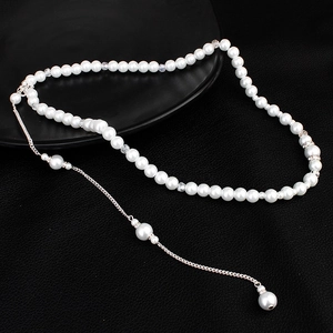 Elegante lange Braut-Körperkette mit weißen Perlen und Kristallakzenten auf schwarzem Grund