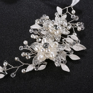Elegant bridal headband featuring white pearls, crystals, and silver leaves for weddings