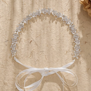Bandeau de mariée élégant avec fleurs argentées, perles et cristaux sur fond texturé