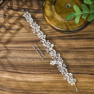 Elegant bridal hair band with white flowers, crystals and pearls on wood background