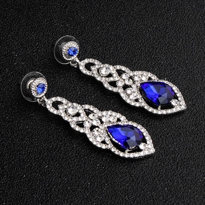 Detail of silver wedding earrings with teardrop blue gems and white zircons