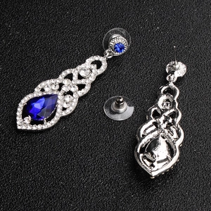 Detailed view of silver bridal earrings with blue pear-cut stones and crystal diamonds