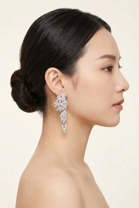 Detailed view of layered wing drop earrings with sparkling crystals worn by a model