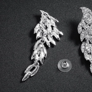 Elegant silver wing drop earrings with sparkling rhinestones for women on black texture
