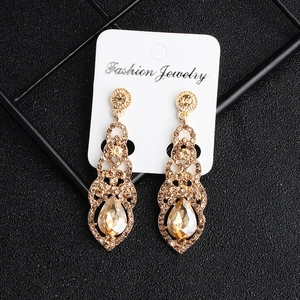 Close-up of golden vintage bridal earrings with champagne crystal teardrops