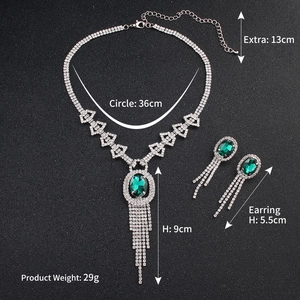 Dettaglio del set collana e orecchini in argento con gemme verdi e strass scintillanti