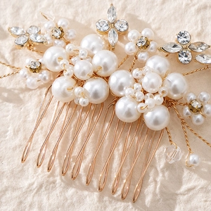 Close-up of handmade bridal hair comb with elegant pearls, rhinestones, and gold wire detail