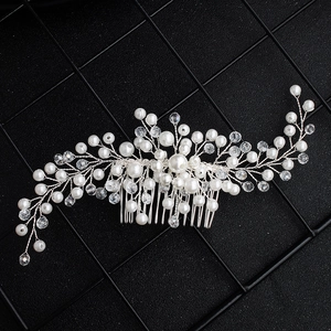 Detailed macro view of handmade bridal hair comb with pearls and clear crystals