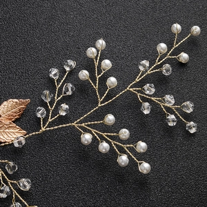 Detail of handmade bridal headband with gold metal leaves, white pearls and clear crystals