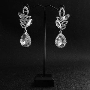 Detail of luxury bridal teardrop earrings with leaf patterns and marquise crystals