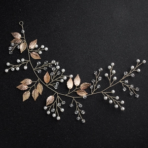 Detailed macro shot of handmade bridal hair vine with golden leaves and crystals