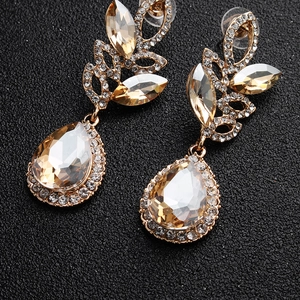 Detailed macro view of champagne teardrop crystals on gold bridal chandelier earrings