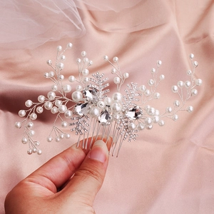 Close-up of bridal hair comb featuring white pearls, crystals and snowflake elements