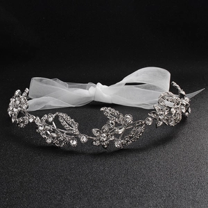 Detail of silver bridal headband featuring floral crystal rhinestones and white organza ribbon