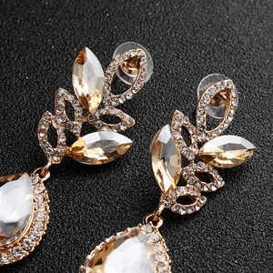 Macro detail of luxury vintage bridal earrings with champagne crystal and leaf design