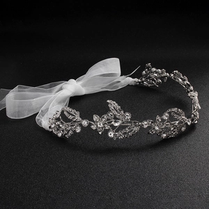Detail of silver bridal headband with sparkling rhinestones and white mesh ribbons