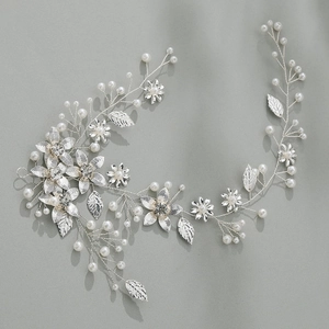 Détail d'une vigne de cheveux de mariée avec feuilles argentées, perles et cristaux