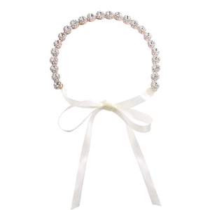 Detailed view of bridal headband with sparkling rhinestones and a white satin ribbon bow