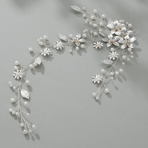 Détail d'une vigne de cheveux de mariée argentée avec feuilles, perles et cristaux