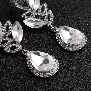 Macro detail of luxury silver drop earrings with marquise and teardrop crystals