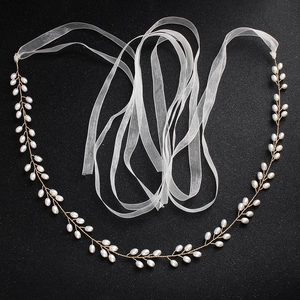 Détail de la ceinture de mariée en perles faites main avec ruban en organza blanc