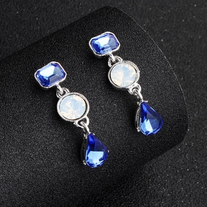 Macro detail of blue crystal marquise drop earrings with elegant vintage silver setting