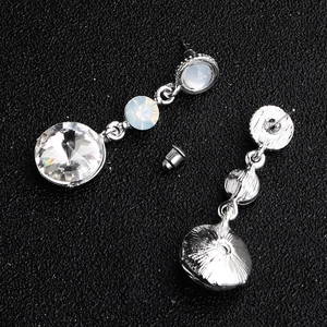 Detail view of silver bridal earrings featuring clear crystals and butterfly back clasps