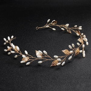 Detailed macro view of handmade gold vine bridal headband with pearls and leaves