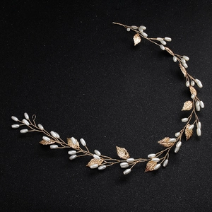 Detail of bridal gold wire hair vine with white pearls and delicate metal leaves