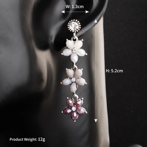 Detailed view of floral drop earrings with gradient resin petals and crystal studs