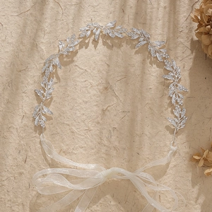Silver bridal leaf hair vine with crystals and white ribbon on a natural background