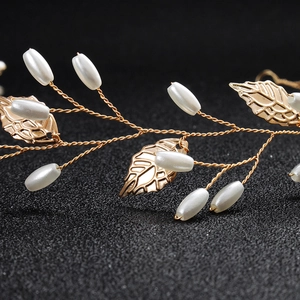 Detailed close-up of handmade gold wire bridal headband with pearls and metallic leaves