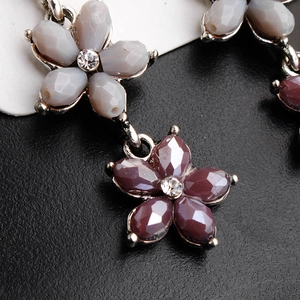 Close-up of vintage bridal earrings featuring layered flower resin beads and rhinestones
