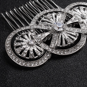 Close-up of three interlocking silver rings encrusted with rhinestones on a 10-tooth hair comb