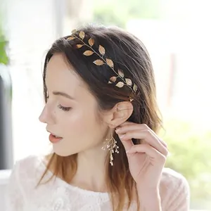 Macro detail of bridal hairband with golden leaf pattern and matching tassel earrings